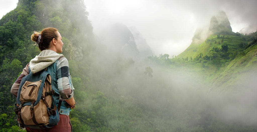 Voyageur observant le paysage montagneux du Nord Vietnam dans la brume matinale